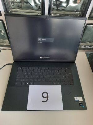 un ordinateur portable ouvert posé sur une table sur laquelle figure le chiffre 9