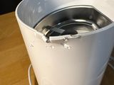 a white bucket with a metal lid sitting on a wooden table