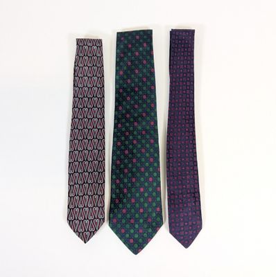three ties are lined up in a row on a white surface