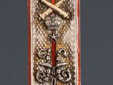 une image représentant une plaque métallique sur laquelle figurent une croix et un serpent