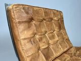 brown leather lounge chair with black metal frame and seat cushion