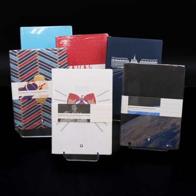 several different types of notebooks are lined up on a black surface