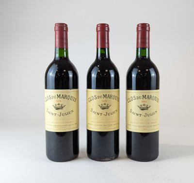 trois bouteilles de vin rouge posées sur une table blanche