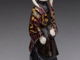 figurine of a woman with a hat and a bag