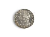 a close up of a silver coin on a white surface