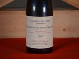 a bottle of wine sitting on a table next to a wooden box