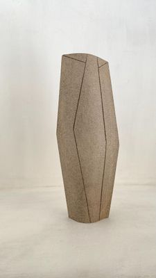 un vase brun posé sur une surface blanche
