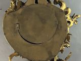 a gold clock with a bird on top of it