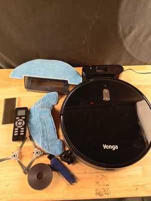 une table sur laquelle se trouvent une télécommande, un chiffon de nettoyage et d'autres objets