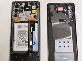 the back of a cell phone with a broken battery and a broken battery
