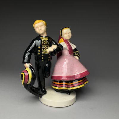 a figurine of a man and a woman holding a suitcase
