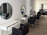 an image of a hair salon with chairs and mirrors