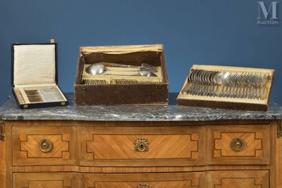 une commode en bois sur laquelle sont posés des couverts en argent
