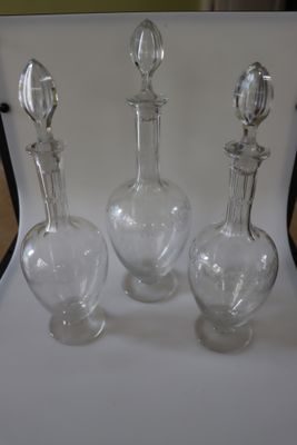 trois carafes en verre posées sur une table blanche