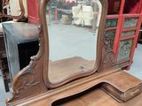 a wooden vanity with a mirror on top of it