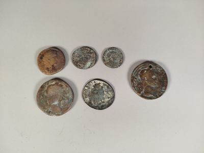 a group of five old coins sitting on top of a white surface