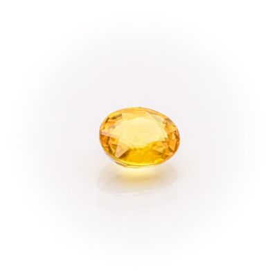 a yellow sapphire stone on a white background