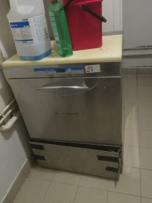 un lave-vaisselle et un récipient posés sur un plan de travail dans une cuisine