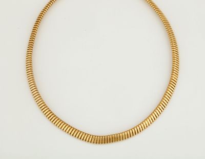 gros plan d'un collier en or sur une surface blanche