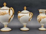 three white and gold vases sitting on a table