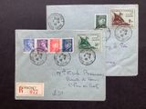 two envelopes with stamps on them sitting on a black surface
