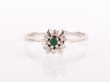 a close up of a ring with a green stone in it