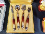three forks and a spoon in a case