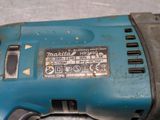 a close up of a corded drill on a table