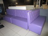 a purple couch that is in the middle of a room
