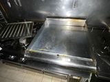 stainless steel stove top in a commercial kitchen with tile flooring