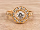 a close up of a diamond ring on a wooden surface