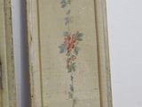 two framed pictures of flowers on the wall in the room