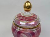 a glass jar with a gold lid on a white surface