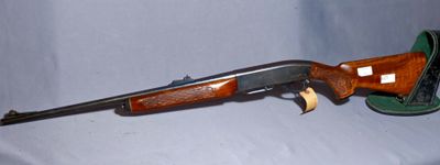 the rifle is laying on a white surface with a green hat
