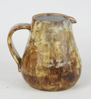 a brown pitcher sitting on a table with a white background