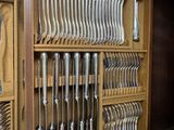 a wooden cabinet with a bunch of silverware in it