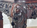 a wooden table with carvings on the top of it