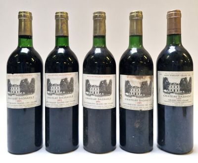 quatre bouteilles de vin sont alignées sur une surface blanche