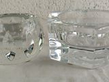 two glass cups sitting on a table with a white background
