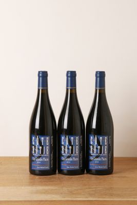 trois bouteilles de vin posées sur une table en bois
