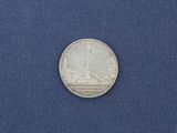 a close up of a silver coin on a blue cloth