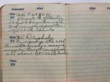 un cahier ouvert, sur lequel figurent des notes, posé sur une table