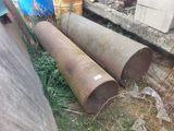 two rusty pipes sitting next to each other on the ground