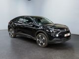 the black suv is parked in a large room with a black floor