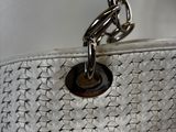 a white purse with a chain hanging from it ' s side