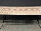 une table avec un plateau en carrelage et des pieds en fer