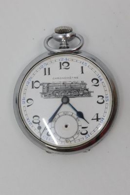 a silver pocket watch with a train on it