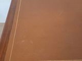 brown leather covered table with gold trim and a wooden frame