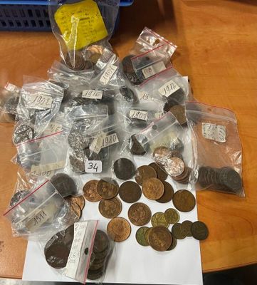 un tas de pièces posé sur une table à côté d'un sac de pièces
