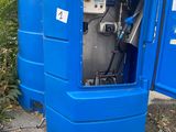 a blue portable toilet sitting outside of a building